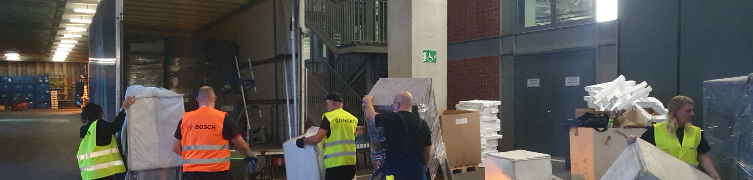 Menschen sortieren und verpacken Kartons in einem Lagerhaus.